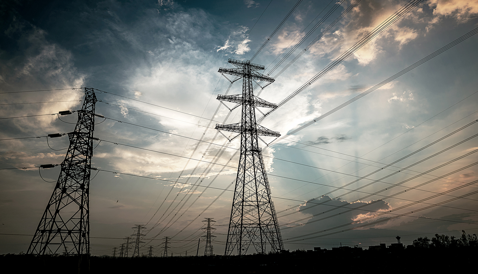 日没時の電力パイロン送電塔