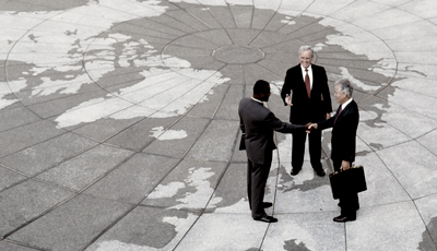 Businessman shaking hands on a map of the globe